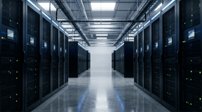 Rows of black server racks with illuminated status lights line a data center aisle.