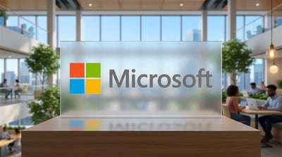 Microsoft logo displayed on a frosted glass sign at a modern corporate office reception desk.
