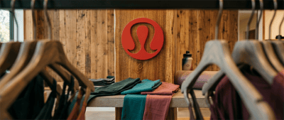 Interior of a Lululemon Athletica retail store showing folded apparel and clothing racks.