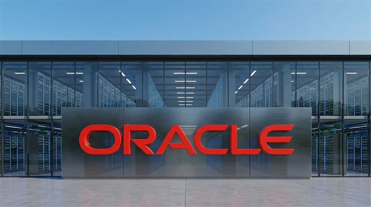 Oracle logo displayed on a metallic sign in front of a data center facility with server racks visible.