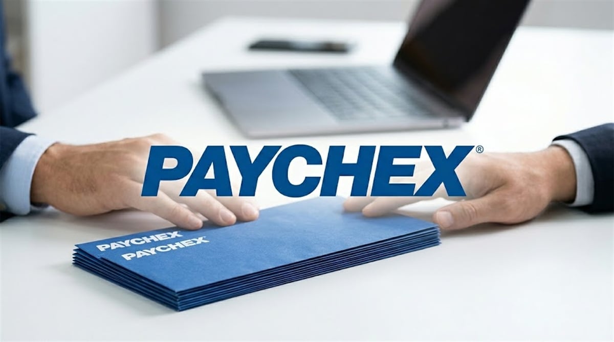 Paychex logo overlaid on two people exchanging branded blue paycheck envelopes across a desk.
