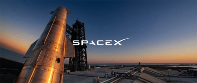 SpaceX Starship rocket stands on the launch pad at sunset with the SpaceX logo overlay.