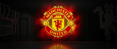 The Manchester United football club crest is displayed as an illuminated logo against a dark background.