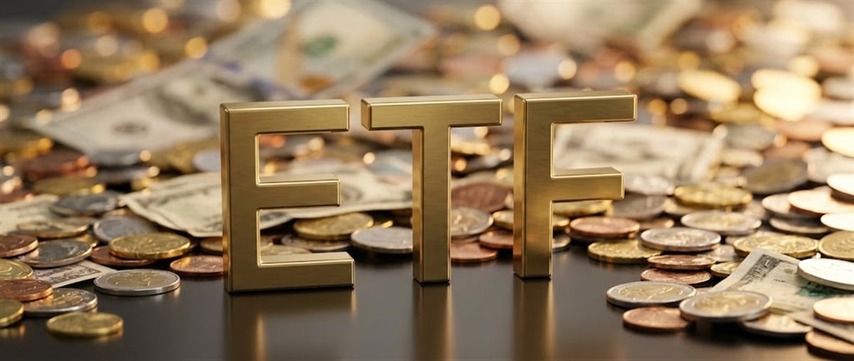 Gold three-dimensional ETF letters rest on a pile of coins and paper currency.