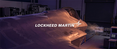 Fighter jet fuselage with cockpit in a hangar displaying the Lockheed Martin logo.