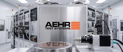 Aehr Test Systems semiconductor testing equipment with logo displayed in a cleanroom manufacturing facility.