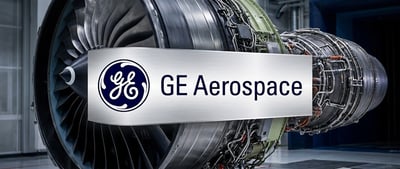 GE Aerospace logo overlaid on a jet engine turbine displayed in an industrial facility.