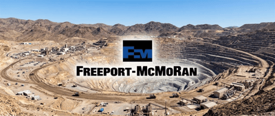 Aerial view of an open-pit copper mine with the Freeport-McMoRan logo overlaid on the desert landscape.