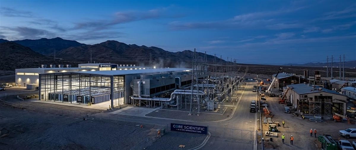Core Scientific data center facility with electrical substation equipment and mountains visible at dusk.
