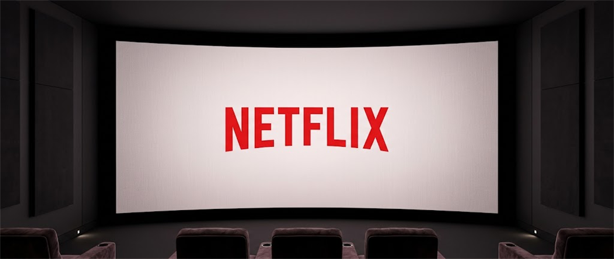 Netflix logo displayed on a large movie theater screen with empty seats in the foreground.