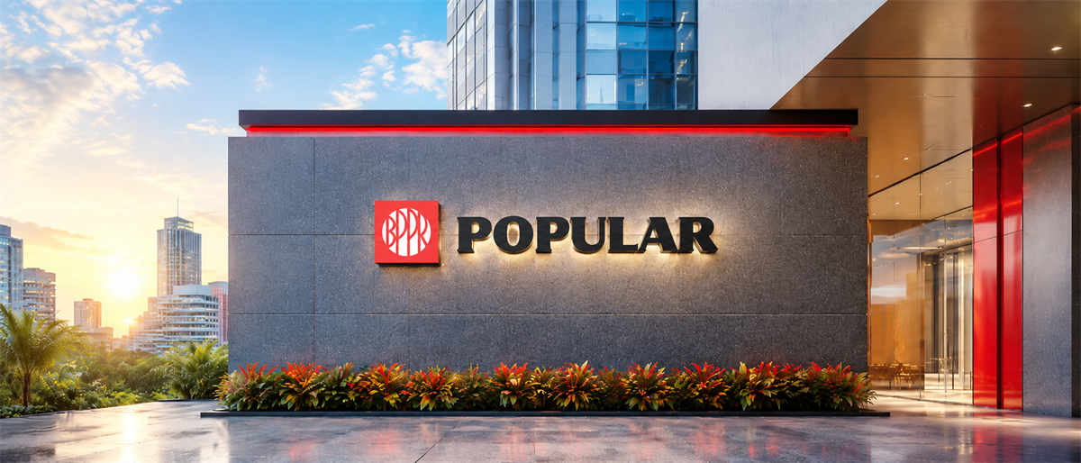 Popular Inc. logo displayed on the exterior wall of a modern corporate building at sunset.