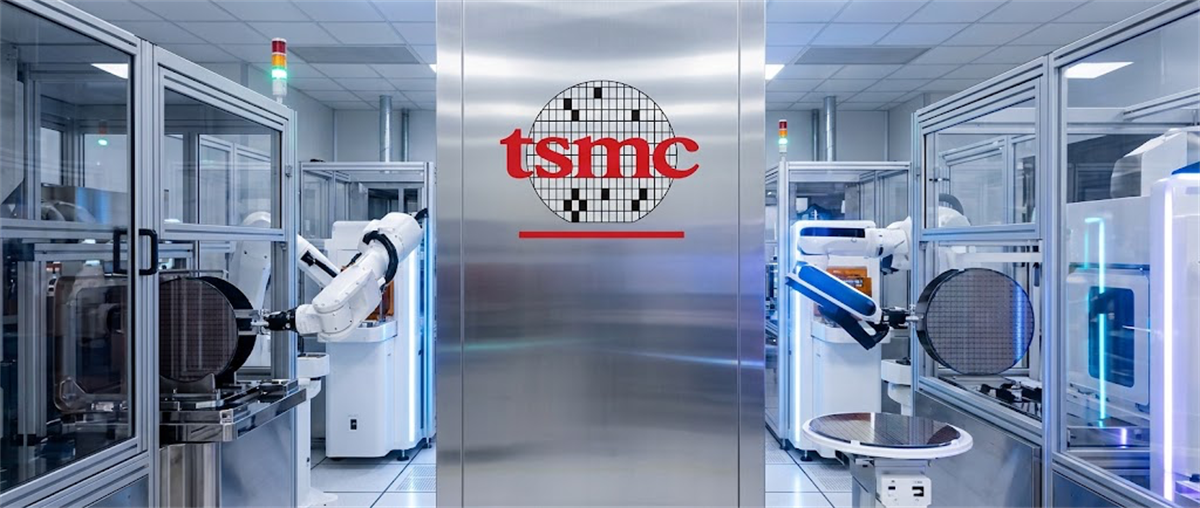TSMC logo displayed on a wall between robotic arms handling silicon wafers in a semiconductor cleanroom.