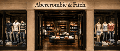 Storefront entrance of an Abercrombie & Fitch retail location, with clothing displayed on mannequins in the window displays.