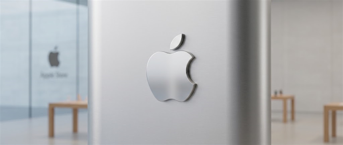 Metallic Apple logo mounted on a pillar inside an Apple Store, with the storefront glass entrance visible in the background.