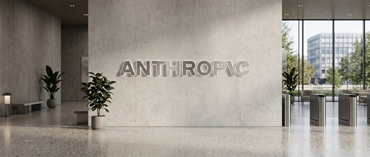 Office lobby with the Anthropic logo mounted on a concrete wall, potted plants, and glass entrance doors.
