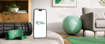 Smartphone displaying the Hinge Health logo on an ottoman, surrounded by foam rollers, a resistance band, and exercise ball.