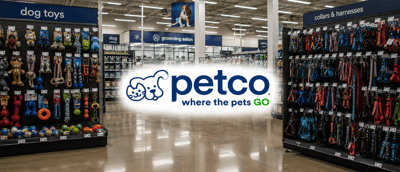 Interior of a Petco store showing dog toys and collar aisles with the Petco logo overlaid.
