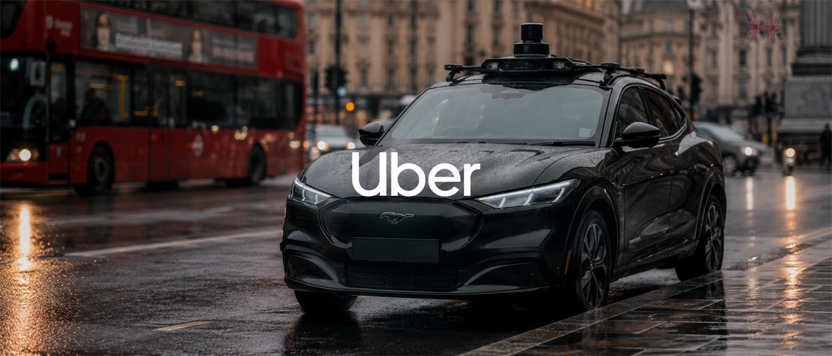 A black autonomous vehicle with rooftop sensors displays the Uber logo on a rainy city street.
