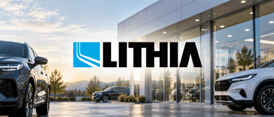 Lithia logo displayed over a car dealership showroom with vehicles parked in front of the glass building.