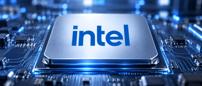 Intel logo displayed on a computer chip embedded in an illuminated blue circuit board.