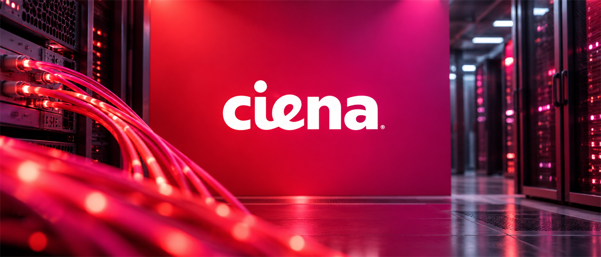 Ciena logo on a red wall in a data center corridor with illuminated fiber optic cables and server racks.