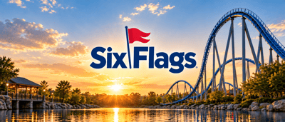 Six Flags logo displayed over a roller coaster and lake at sunset in an amusement park setting.