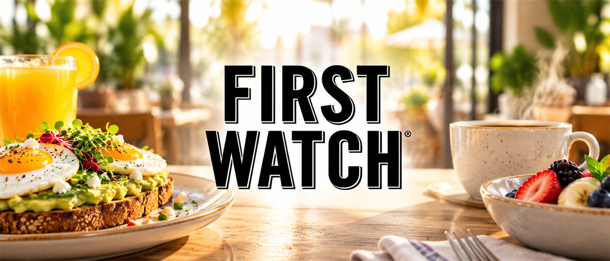 First Watch logo displayed over a breakfast table with avocado toast, fruit bowl, coffee, and orange juice.