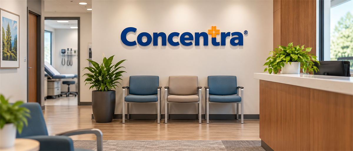 Concentra logo displayed on a wall in a medical clinic waiting area with chairs and an exam room visible.