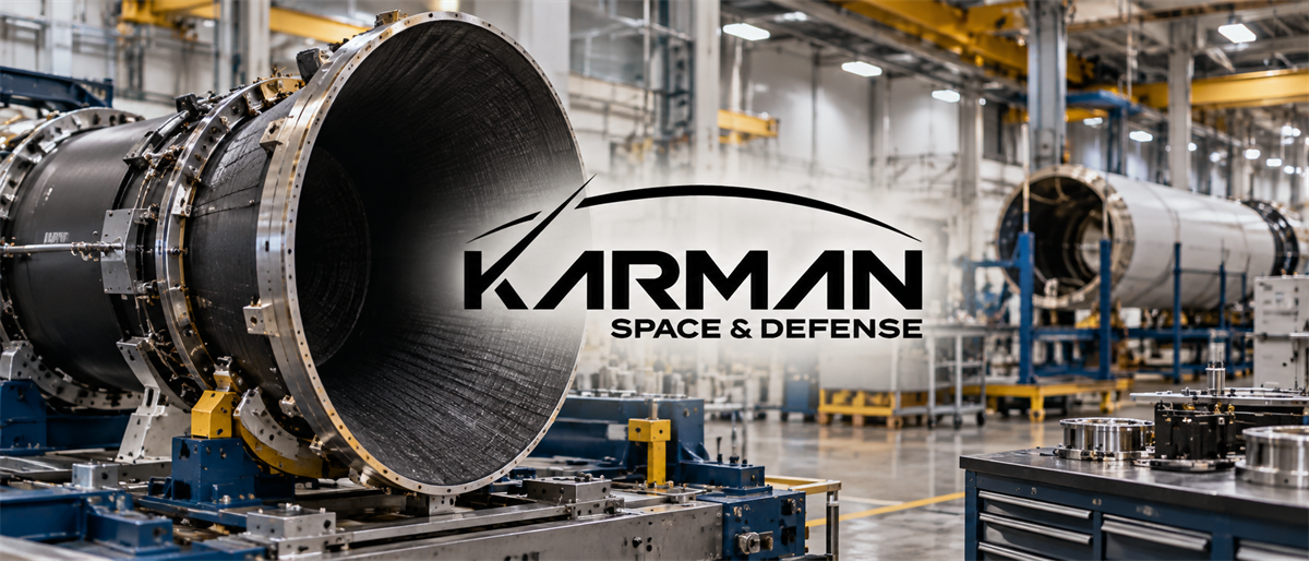 Karman Space & Defense logo overlaid on a factory floor with large cylindrical aerospace components in production.