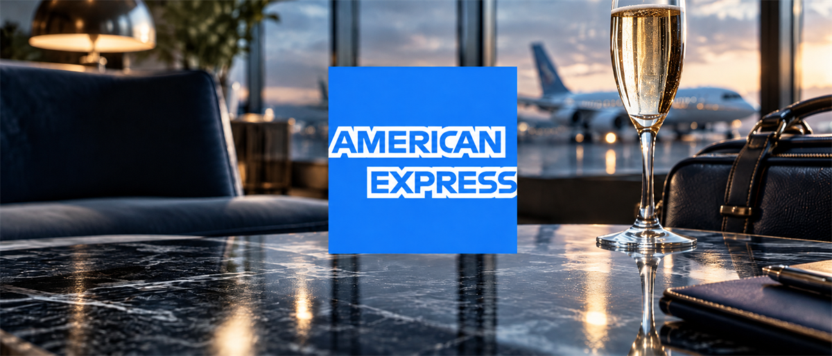 American Express logo displayed on a table in an airport lounge with champagne and an airplane visible outside.