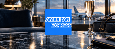 American Express logo displayed on a table in an airport lounge with champagne and an airplane visible outside.
