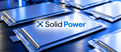 Solid Power logo displayed over an image of flat, solid-state battery cells arranged on a dark surface.
