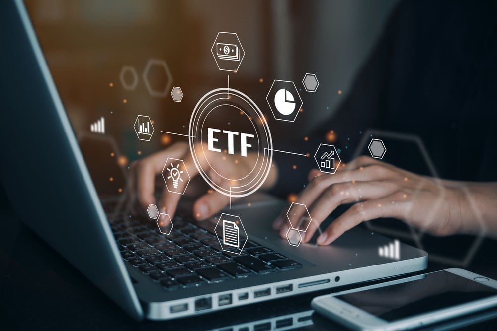 Person working on computer on the ETF exchange traded fund; learn about the best fintech ETFs