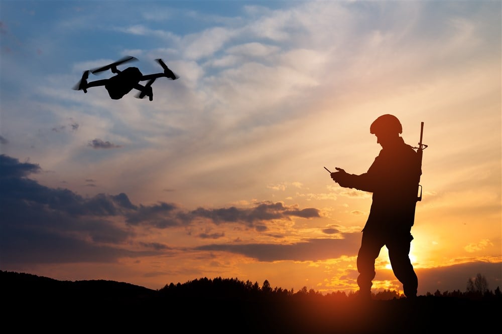 Silhouette of soldier using drone