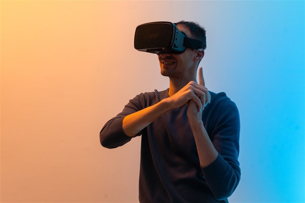 man with virtual reality glasses pointing up