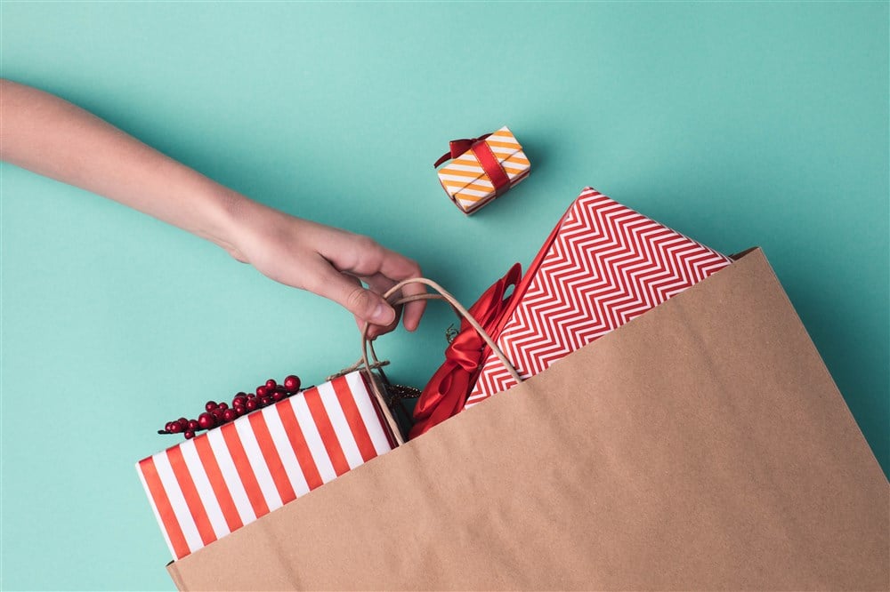 decorated presents inside brown paper shopping bag