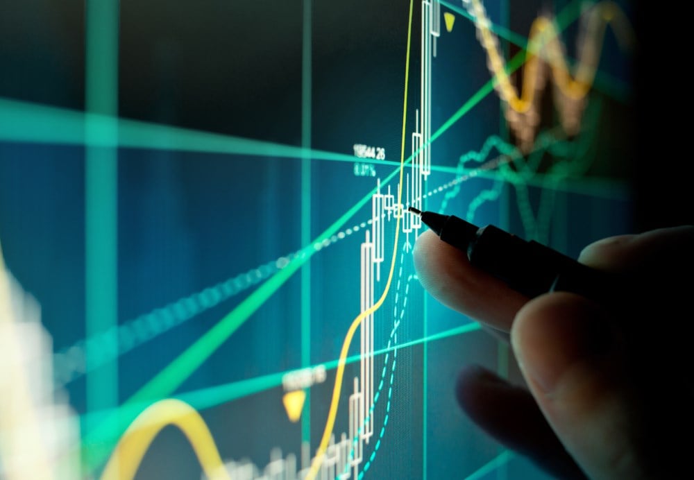 A stock trader checking technical markers of a stock on a computer screen.