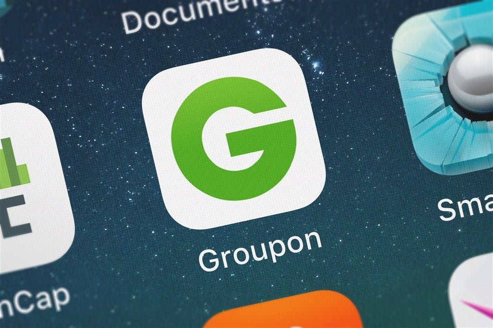 Groupon mobile app logo on background of mobile device
