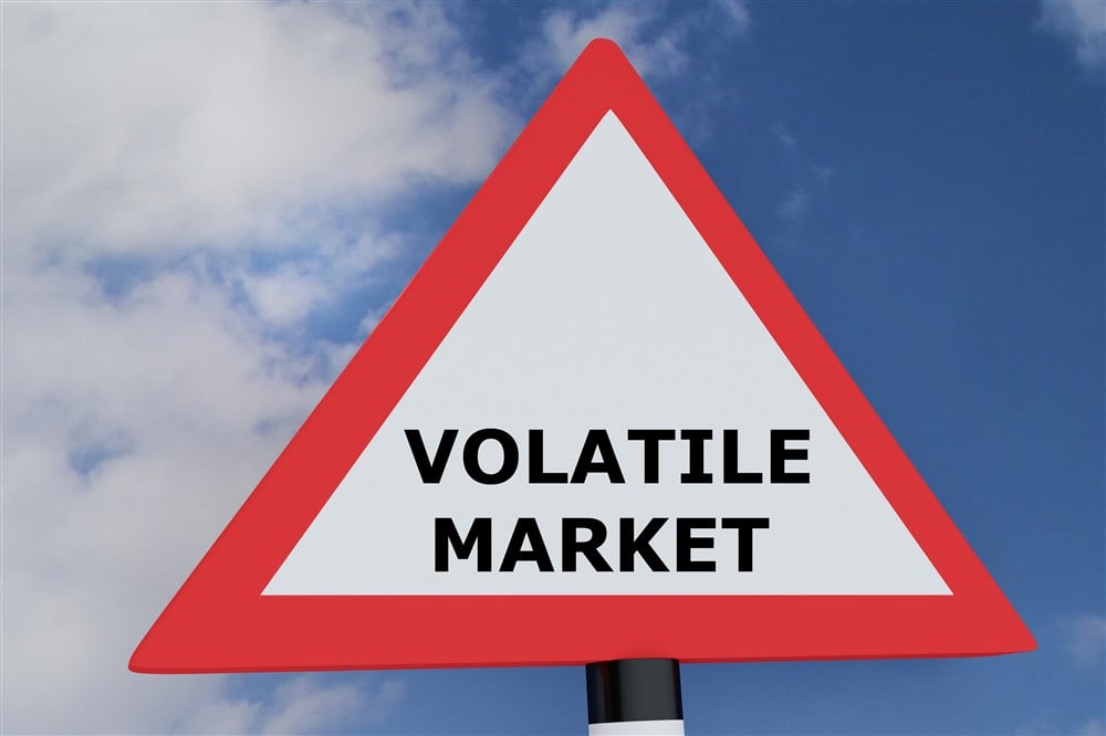 red and white road sign with Volatile Market message in black type