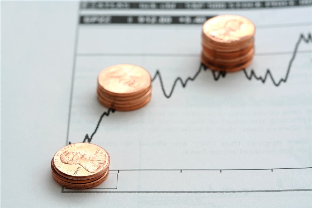 Stacks of pennies placed on stock chart illustration