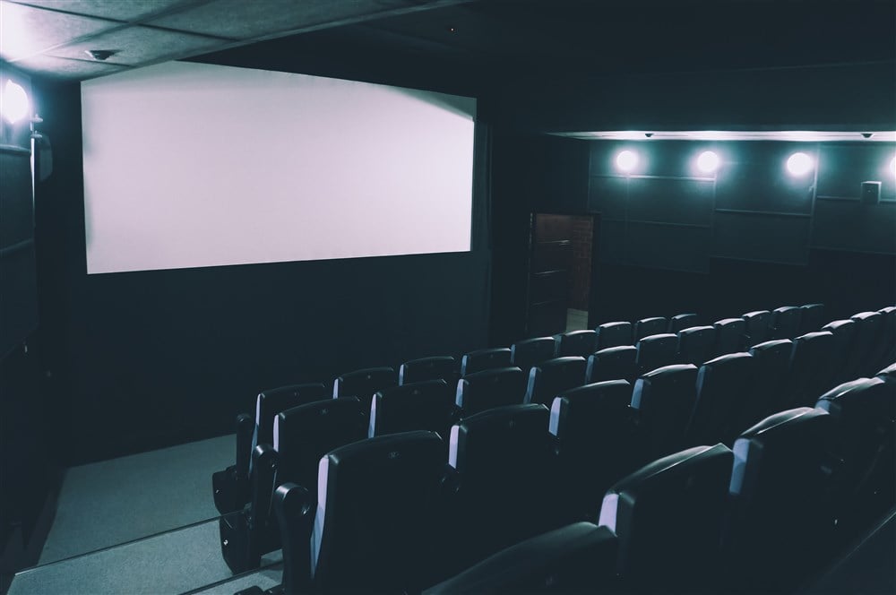 interior of cinema with black seats and blank movie screen