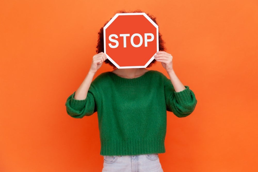 What is a stop order? Image of a woman hiding her face behind red stop traffic symbol