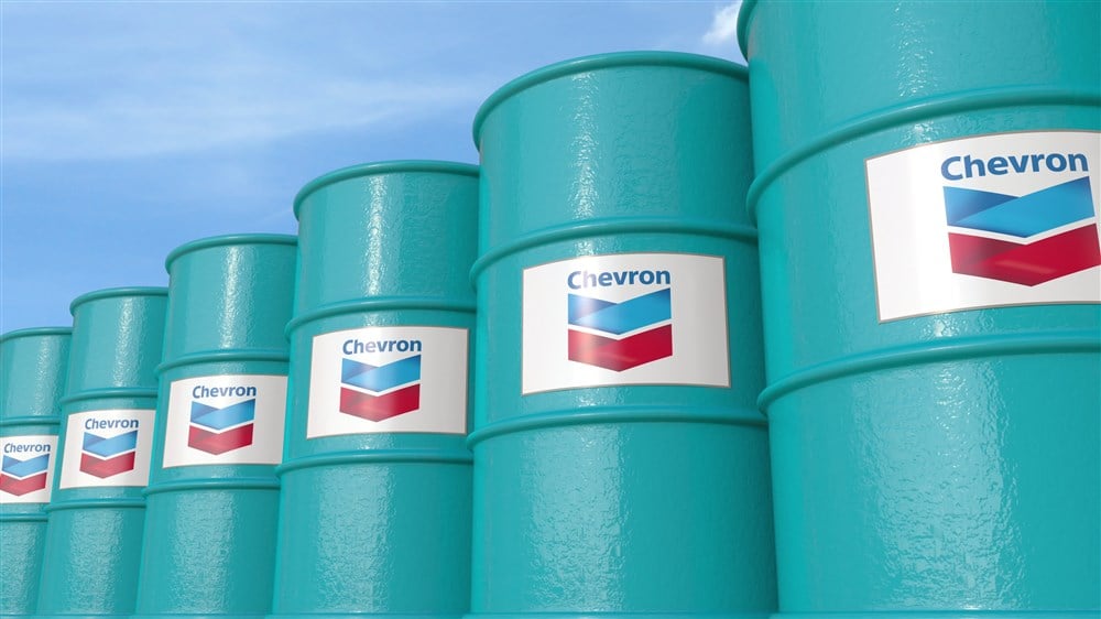 Row of metal barrels with Chevron Corporation logo against sky
