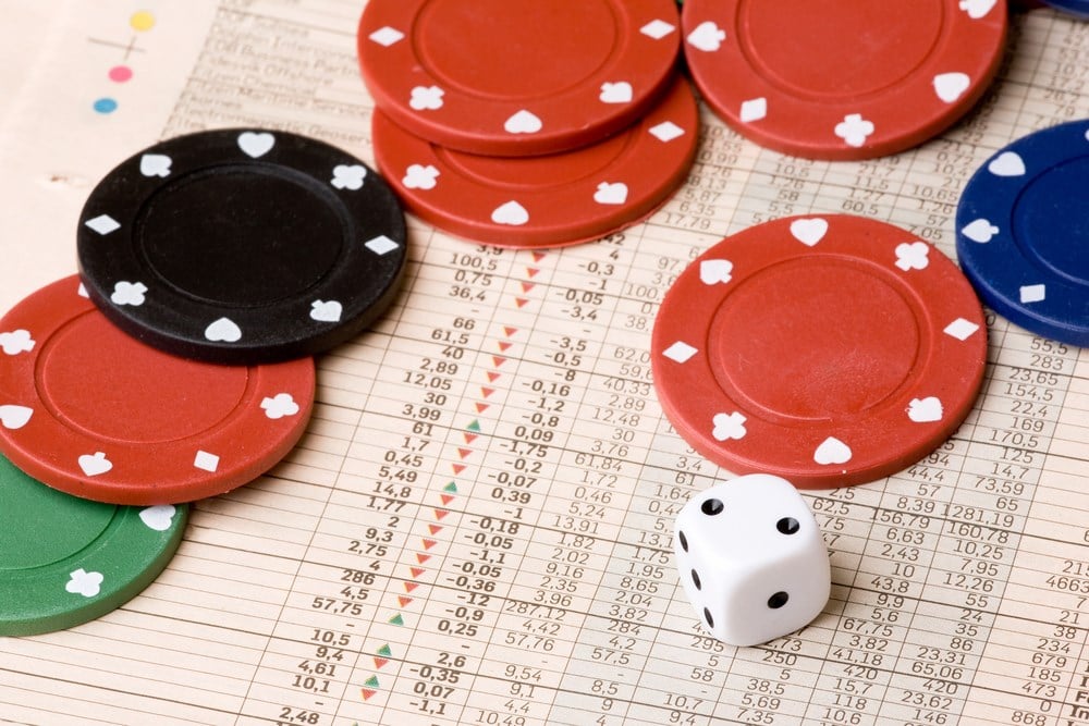 Dice and casino chips on a stock market chart; overview of 