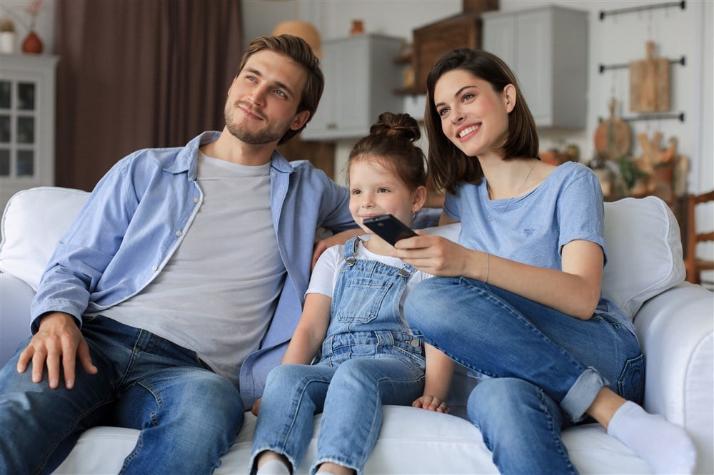 image of family watching tv on couch