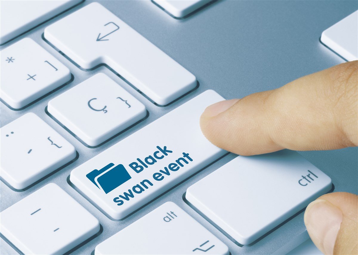 Black swan event words on key of computer keyboard with finger 