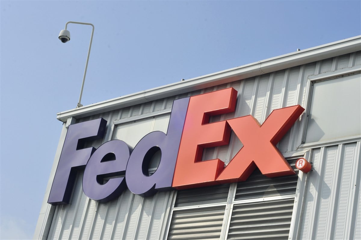 FedEx logo on the side of a building; learn more about FedEx stock