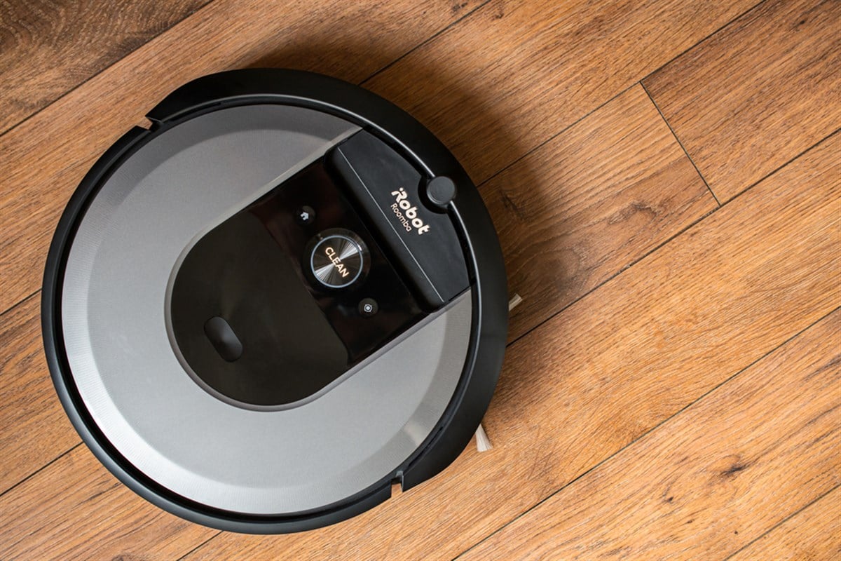 iRobot Roomba i7 robot vacuum cleaner on a wooden floor, illustrative editorial.
