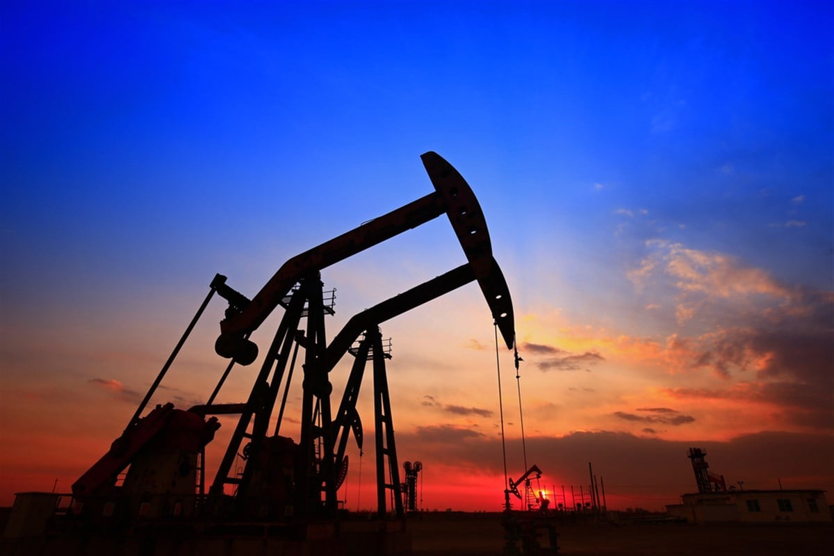 Oil pump and energy equipment in the sunset; learn more about energy stocks