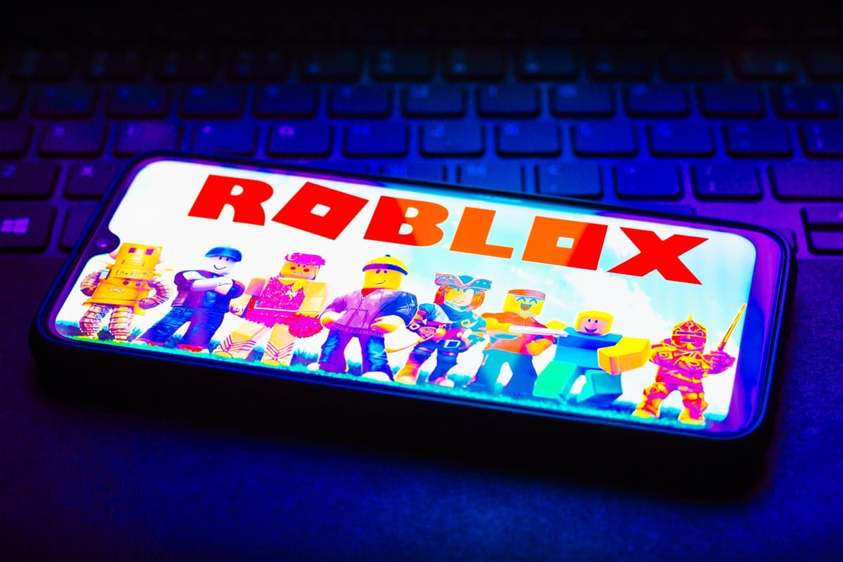 photo of roblox logo displayed on smartphone laying on top of a keyboard